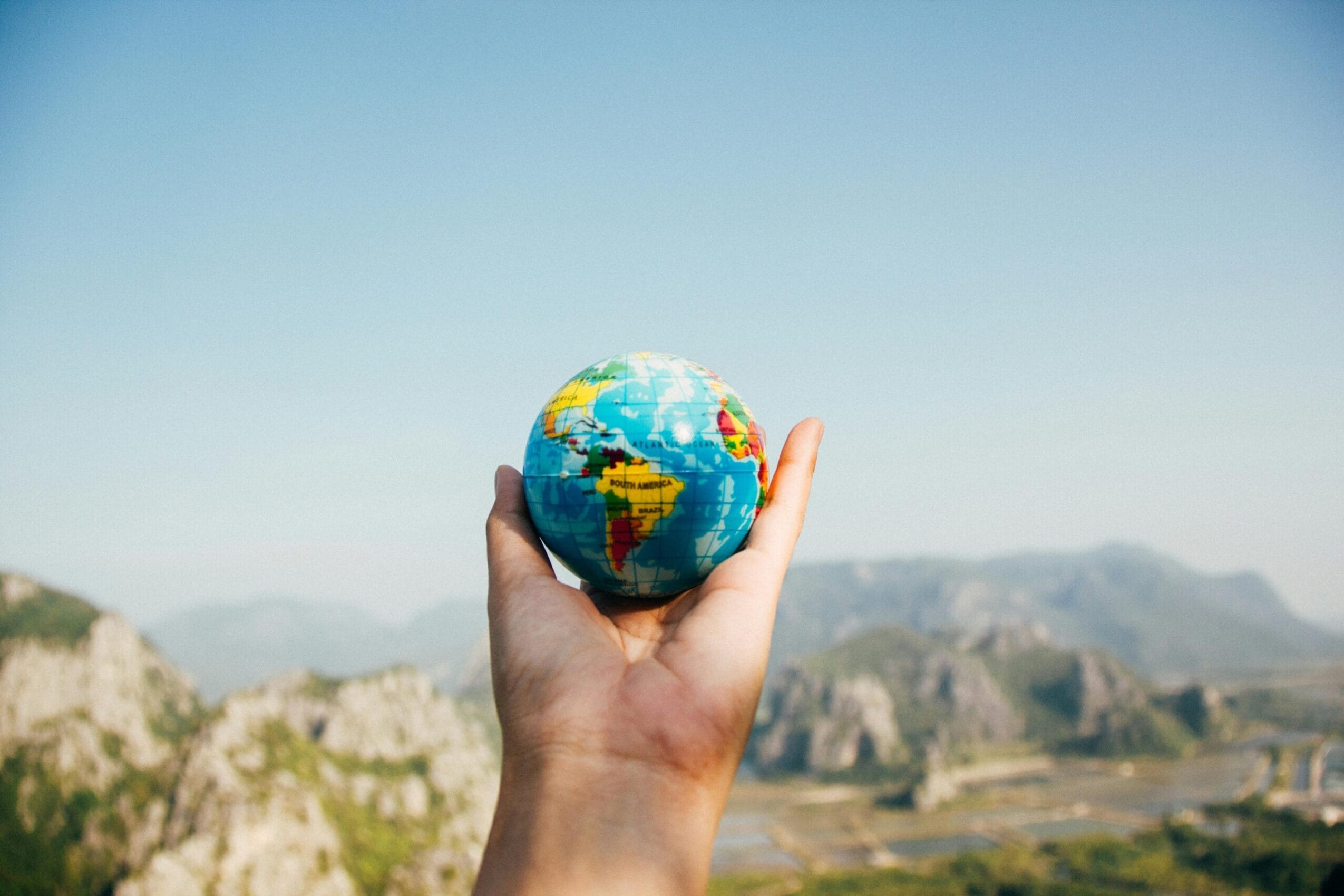 Hand holding a globe symbolizing international travel from Izmir airport, ideal for private transfers to Bodrum, Kuşadası, or Çeşme.