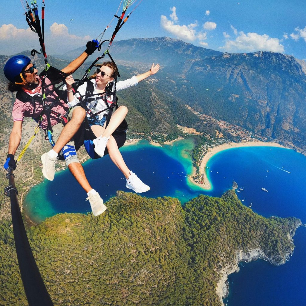 Adventure seekers enjoy paragliding over the stunning Blue Lagoon in Ölüdeniz, Turkey.