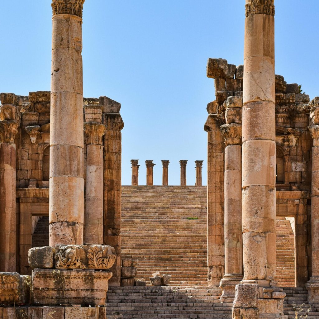 Ancient ruins of the Temple of Artemis in Jerash under a clear blue sky.