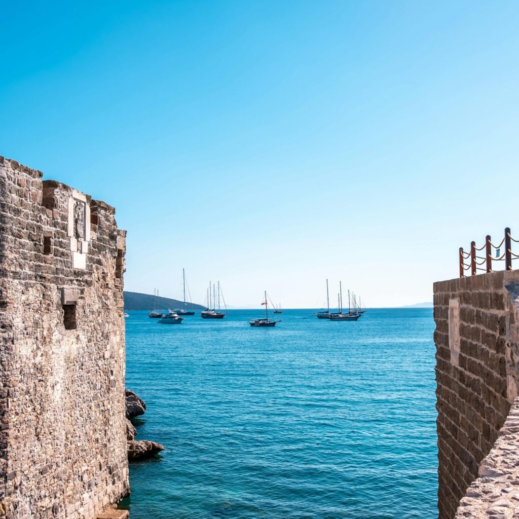 Bodrum Castle & Marina – VIP Transfer from Bodrum Airport View of Bodrum Castle and luxury yachts on the Aegean Sea, ideal for VIP transfer services from Bodrum Airport to Yalıkavak, Türkbükü, and marina resorts.