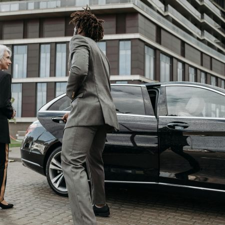 pexels-photo-8425050-8425050 Business professionals exiting luxury car near modern building in city setting.